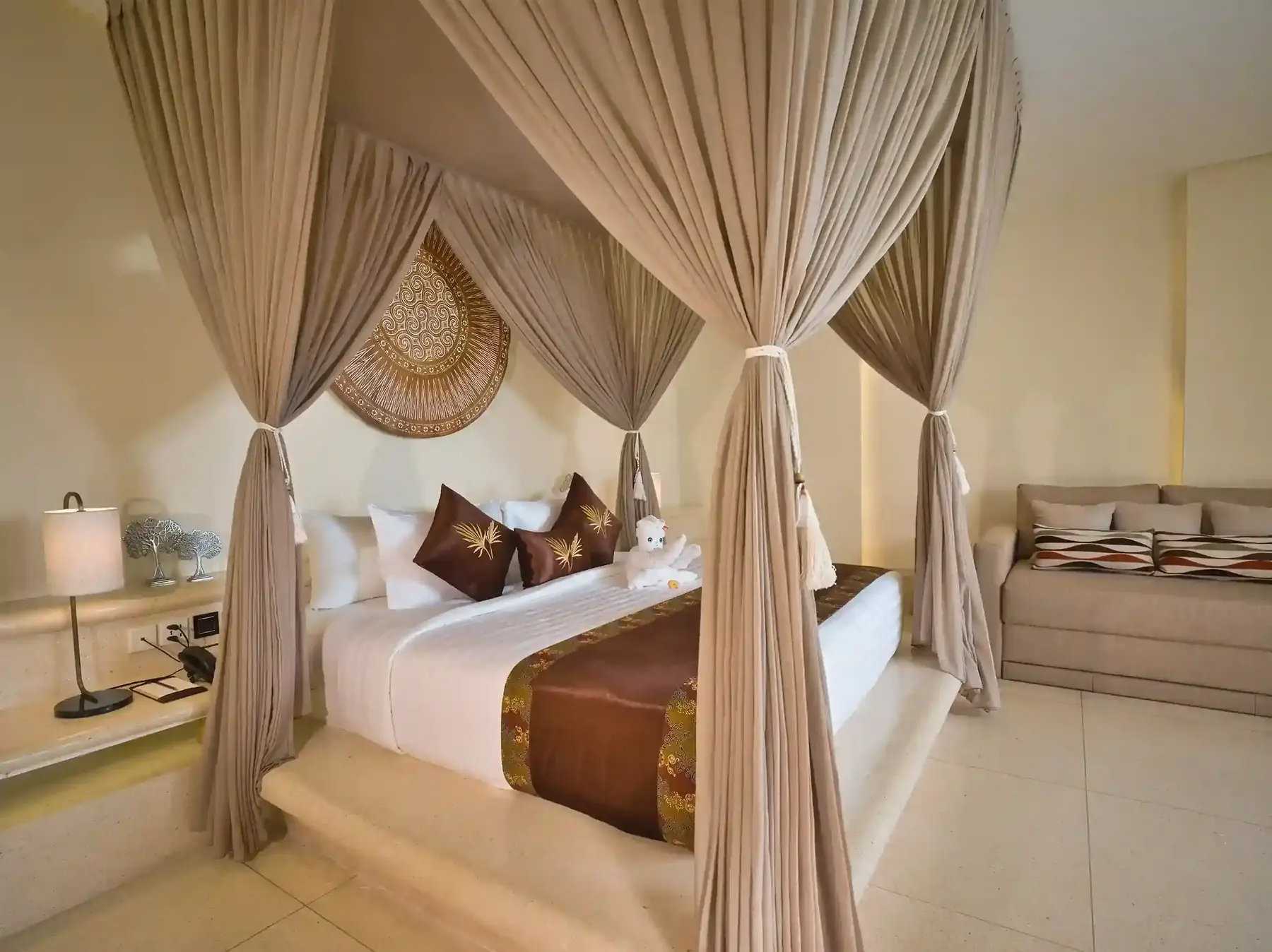 Canopy bed beneath a round woven wall piece