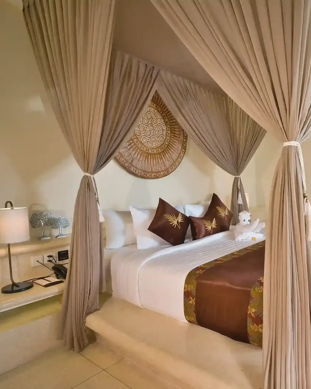 Round woven wall piece above a canopy bed in a Bali villa